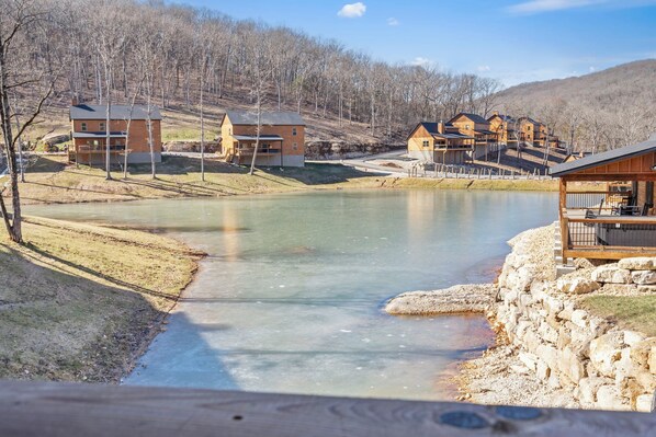 A lakeside property with multiple cabins, a dock, and a stone wall.