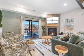 Una sala moderna con chimenea, un conjunto de sofás, una mesa de comedor y vistas al exterior.