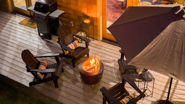 Une terrasse dotée de mobilier d’extérieur, d’un foyer et d’un espace abrité.
