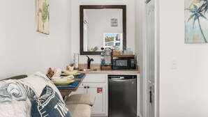 A compact kitchen with a microwave, coffee maker, and dishwasher. - Hot Tub, 10min walk to Beach at Tiny Treasure (Panama City Beach)