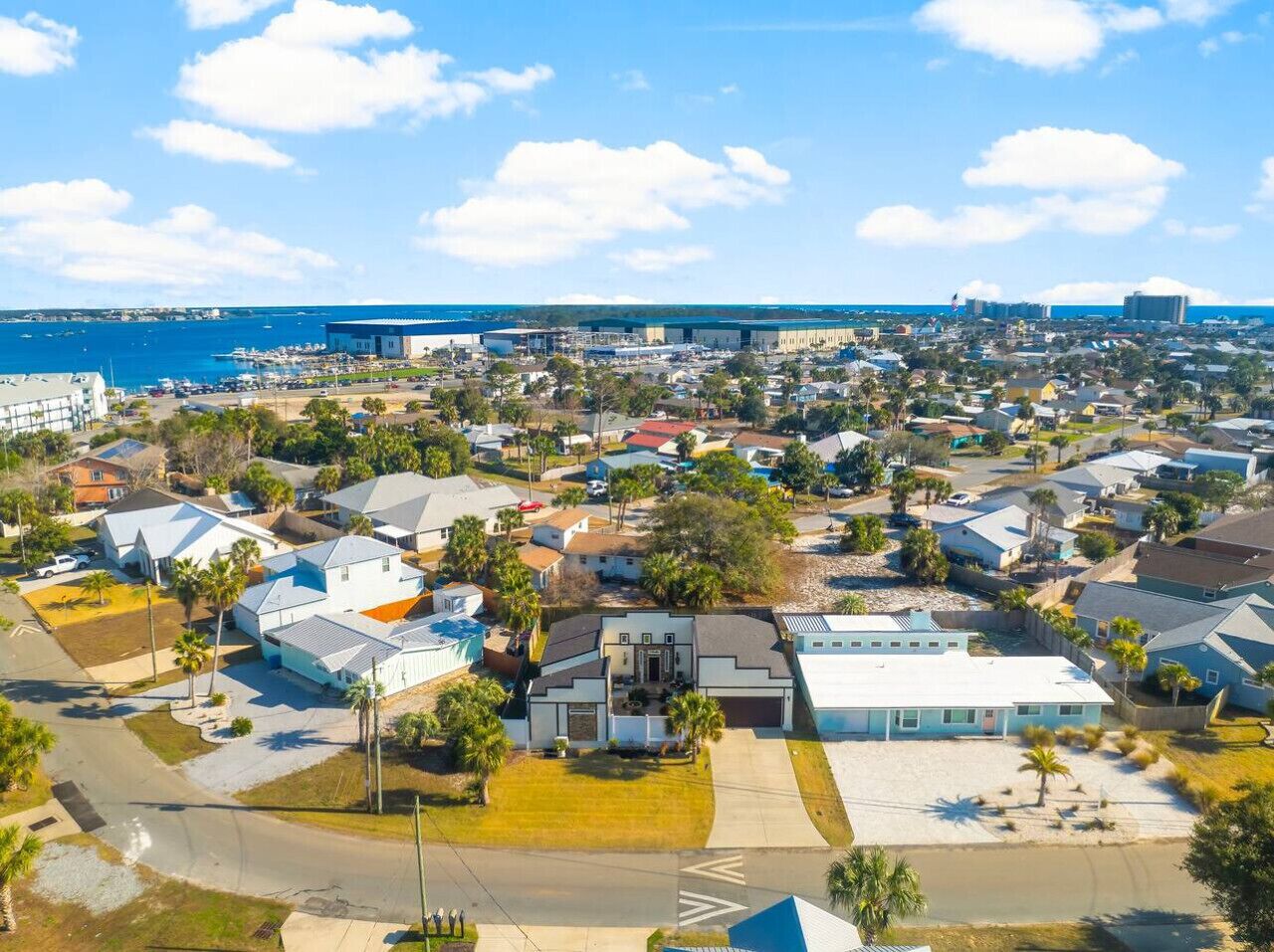 Vista aérea de una zona residencial con casas, calles y un puerto deportivo.