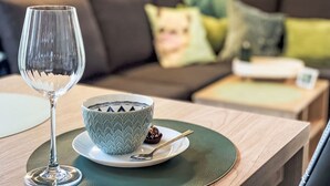 Een eetgedeelte met een glazen tafel, een schaal met een geometrisch patroon en een lepel op een bord.