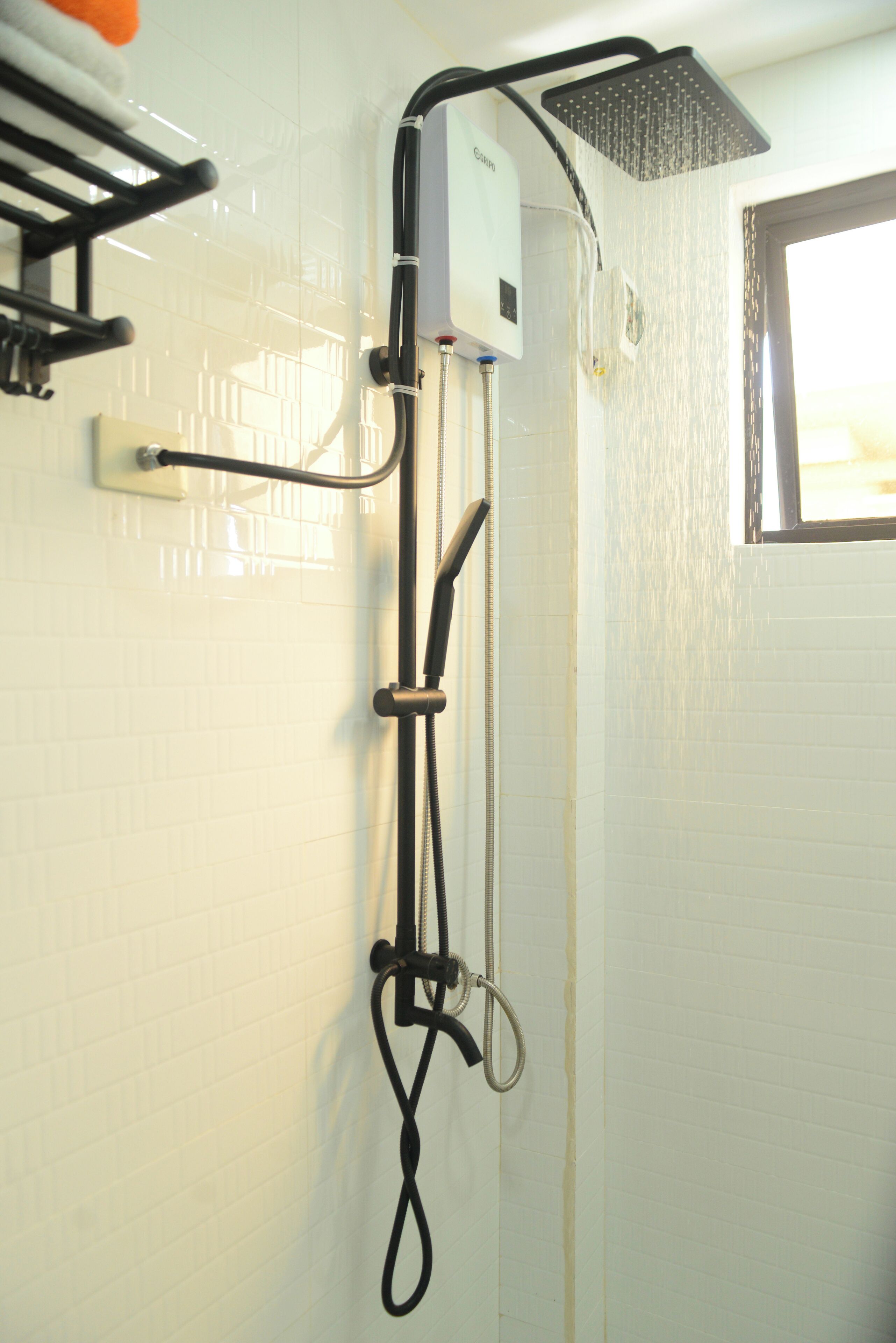 A shower with a handheld showerhead and a wall-mounted rain showerhead.