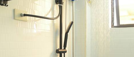 A shower with a handheld showerhead and a wall-mounted rain showerhead.