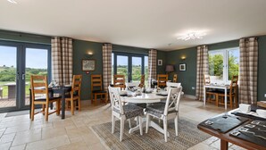 A dining area with a round table, chairs, and a view of the outdoors. - The Duck Pond - Countryside Hot Tub (Narberth)