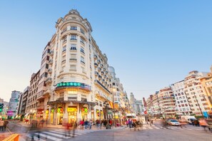 Een meerlaags hotel met een klassiek architectonisch ontwerp, met балконы en een centrale binnenplaats.