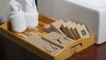 Un baño con una bandeja de madera que contiene toallas y artículos de aseo, un lavabo y un espejo con marco de madera.