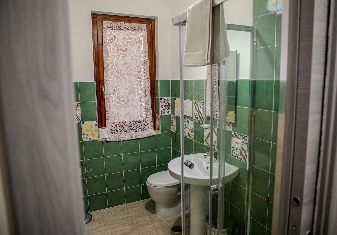 Une salle de bain comprenant des toilettes, un lavabo et un espace douche.