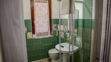 Une salle de bain comprenant des toilettes, un lavabo et un espace douche.