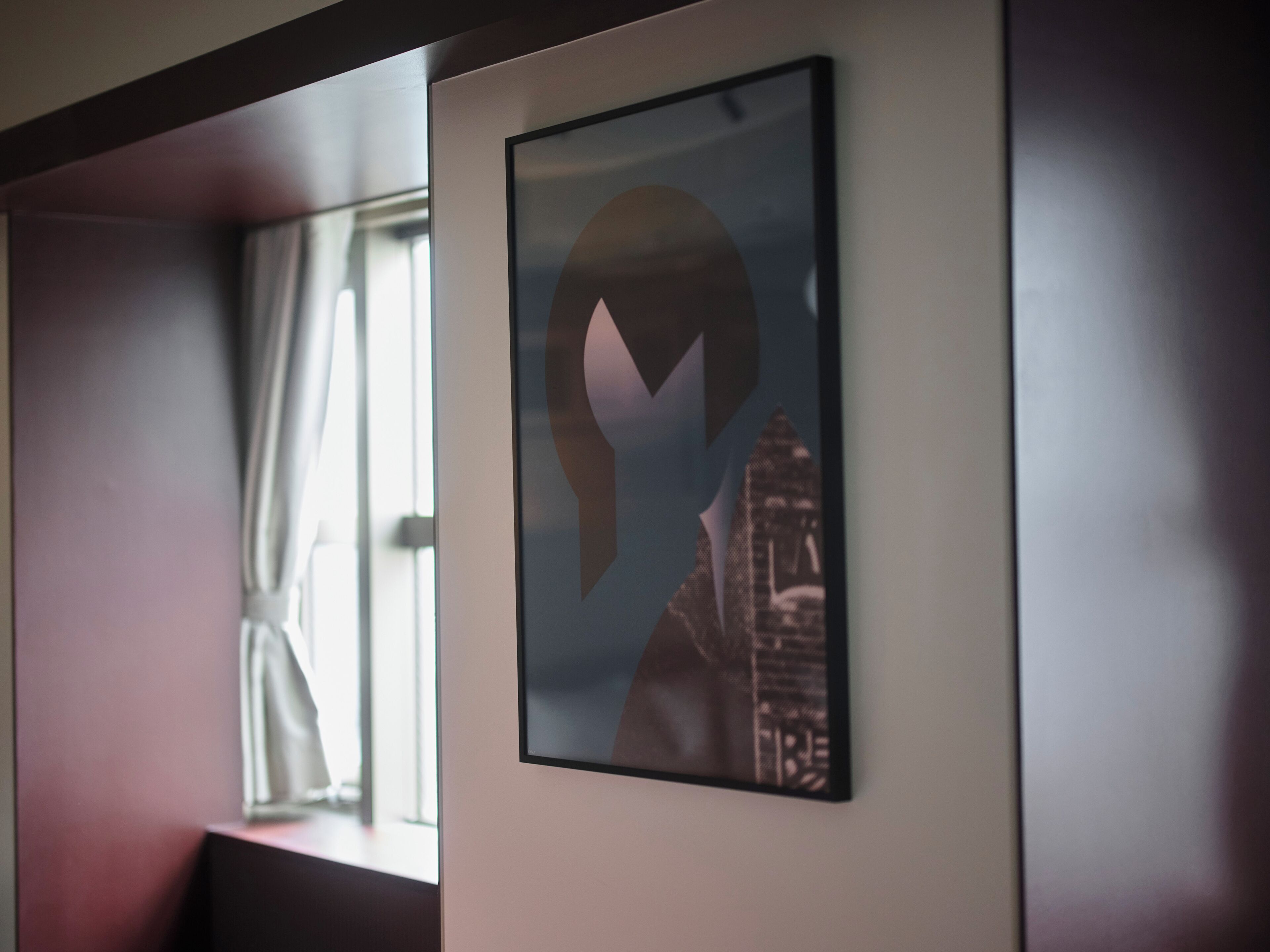 A framed artwork with a geometric design on a wall.