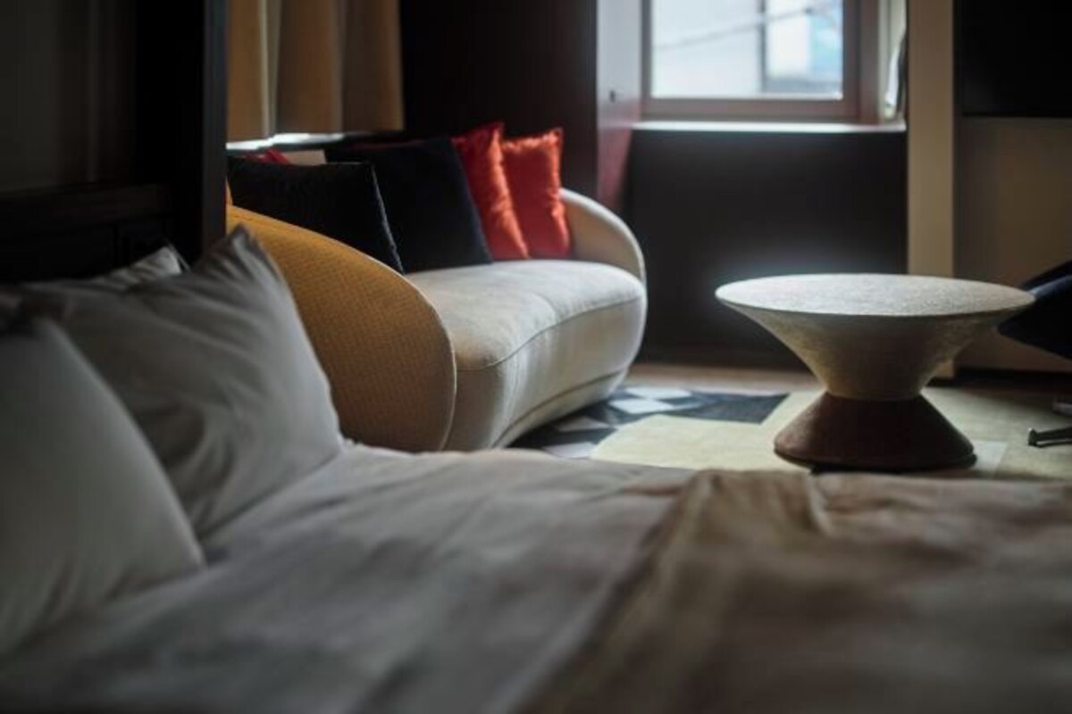Una habitación de hotel con una cama, un sofá y una mesa redonda.
