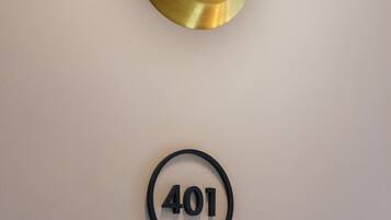 Una lámpara fijada a la pared, con interruptor y un letrero circular con el número 401.