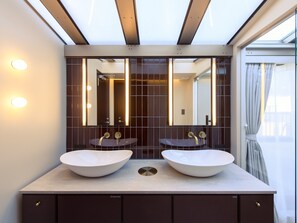 Een badkamer met twee wastafels, een grote spiegel en een dakraam.