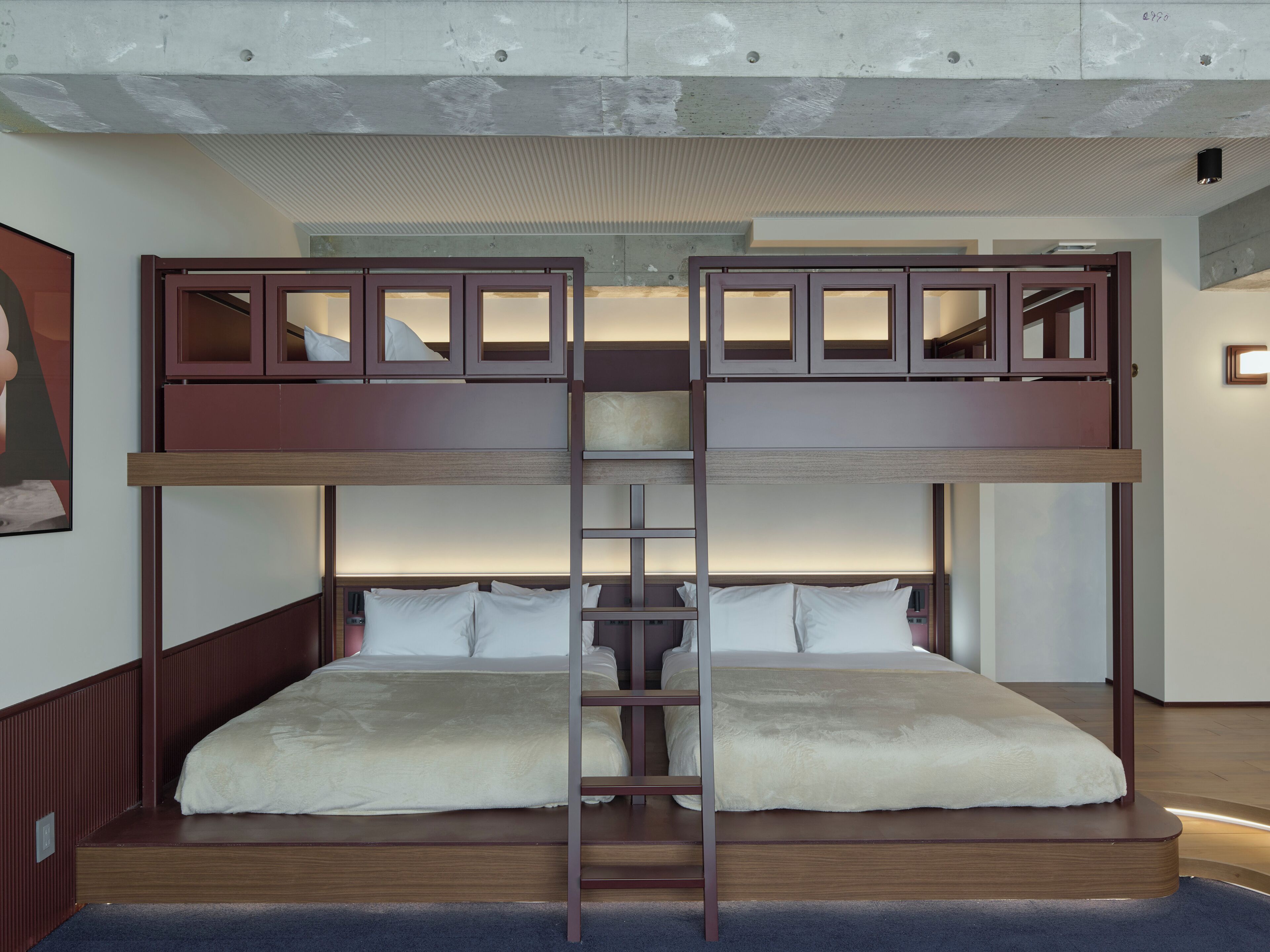 Ein Stockbett mit einer Stehle, einem Holz-Kopfteil und weißer Bettwäsche.