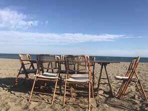 A beach setting with a table and four chairs made of bamboo. - 3070 Luxury Apartment in Terrazas de Marbella, Cabopino (Marbella)