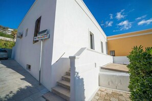 Un bâtiment blanc avec une enseigne indiquant « Parco Gioco » et un escalier menant à une porte.