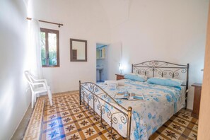 A bedroom with a bed, a chair, a nightstand, a mirror, and a window. - Marisole House With Sea View, Santa Cesarea Terme, Italy (Santa Cesarea Terme)