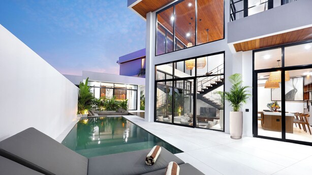 Une maison moderne dotée d’une piscine, d’un escalier et d’un coin repas.