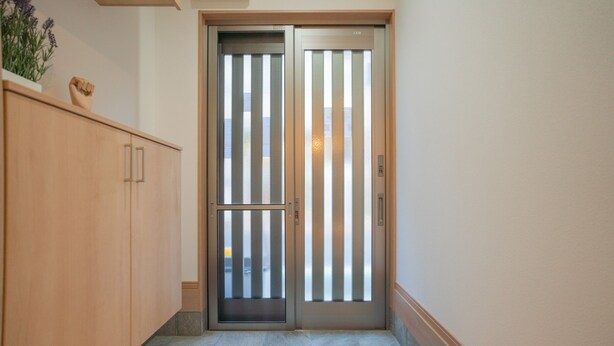 A hallway with a wooden cabinet and a door with vertical blinds. - Travel Time - Teradacho Noake (Osaka)