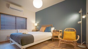 A bedroom with a bed, bedside tables, a chair, a lamp, and a floor lamp. - Travel Time - Teradacho Noake (Osaka)