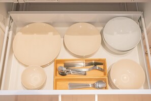 A drawer containing neatly arranged plates, bowls, and cutlery. - Travel Time - Teradacho Noake (Osaka)