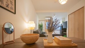 A wooden table with a bowl, a mirror, a vase with dried plants, and a tray with a box. - Travel Time - Teradacho Noake (Osaka)