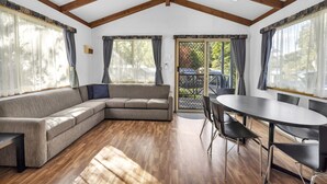 A spacious room with a large sectional sofa, a dining table with chairs, and a ceiling fan. - 2 Bedroom Family Villa (Metung)