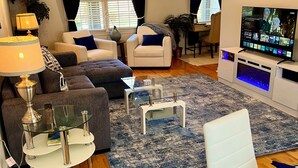 En moderne stue med sofa, lænestol, sofabord og TV-møbel.