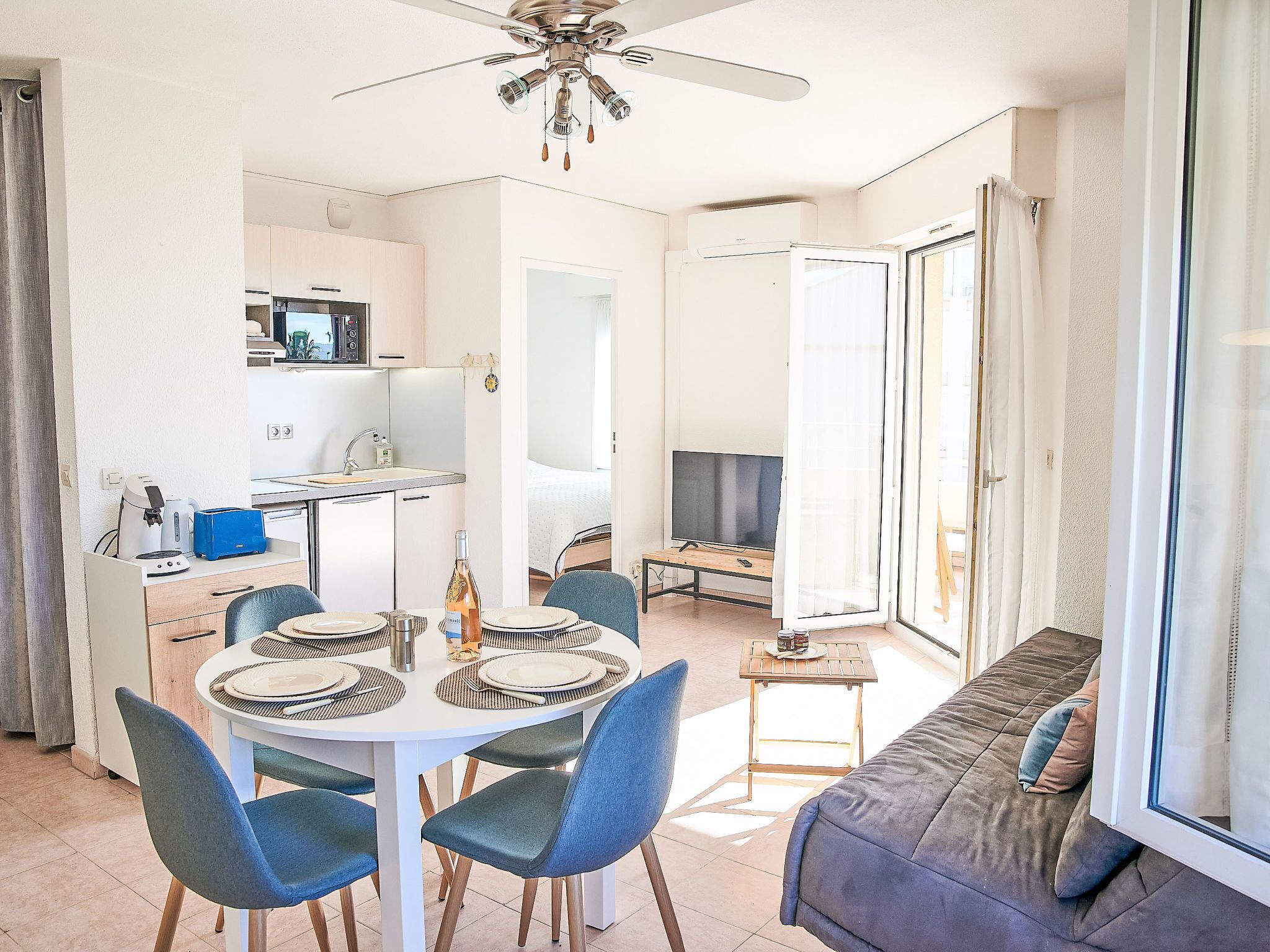 Een moderne woonkamer met een eethoek, een keuken en een balkon.