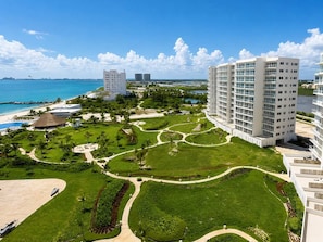 Um resort com piscina, praia e um prédio grande com vários andares.