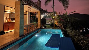 Ein Schwimmbecken mit freier Sicht auf den Poolbereich, inklusive Bar und Sitzgelegenheiten.