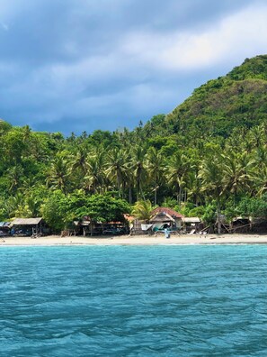 A beach with clear turquoise water, palm trees, and a hilly backdrop. - Villa Maya Bali 3,229 sq ft villa ocean view breakfast included NEW ! (bali)