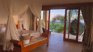 Une chambre à coucher avec un lit, un banc en bois et une vue sur l’extérieur.