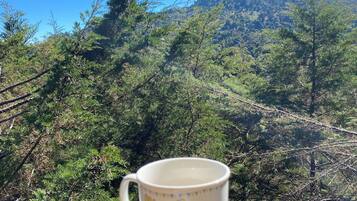 A mug on a railing with a mountainous landscape in the background.