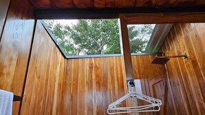 Ein Zimmer aus Holz mit Fenster und Kleiderhänger.