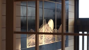 A window with a decorative wooden frame and a view of a mountainous landscape. - decopinhouse (Hanamaki)
