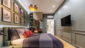 Ein modernes Schlafzimmer mit einem großen Bett, einer eingebauten Bücherwand und einem flachbildfernseher an der Wand.