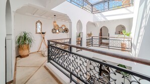Un intérieur spacieux avec un balcon, des murs blancs et des miroirs décoratifs.
