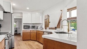 A modern kitchen with white cabinets, a microwave, a toaster, and a sink. - Hikari Haven Dome | Hot Tub,BBQ,Planetarium,Loft (Coarsegold)