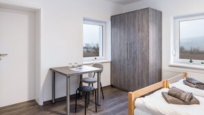 A bedroom with a bed, a desk, a chair, a wardrobe, and two windows. - Haus Fuldablick Room '5' with Shared Garden and Wi-Fi (Rotenburg an der Fulda)