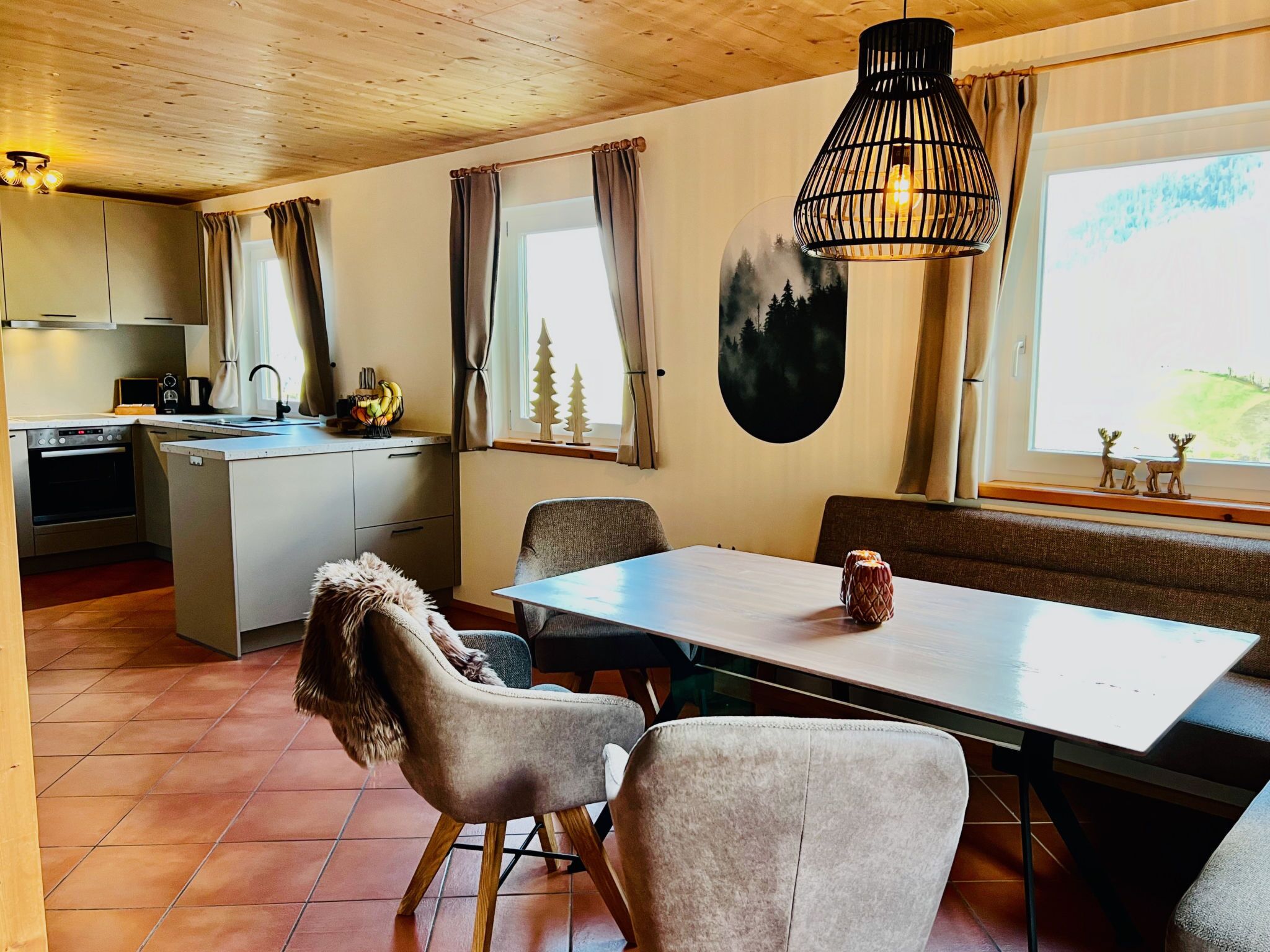 A modern kitchen with a built-in oven and a dining area with a table and chairs.