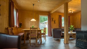Ein gemütliches Blockhausschlafzimmer mit Essbereich, Sitzgelegenheiten und Kamin.
