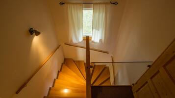 Eine Holztreppe mit Geländer und einem Fenster oben.