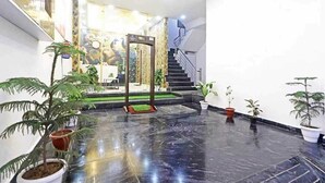A spacious lobby with a marble floor, a staircase, and several potted plants. - Hotel Vijaydeep Place Near Delhi Airport (New Delhi)