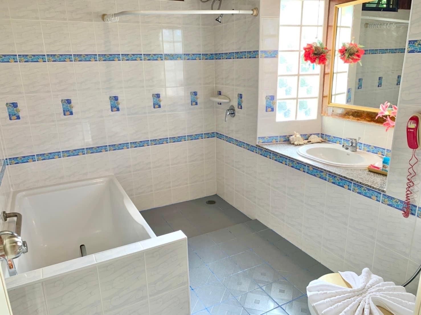 Un baño con bañera, lavamanos y ducha.
