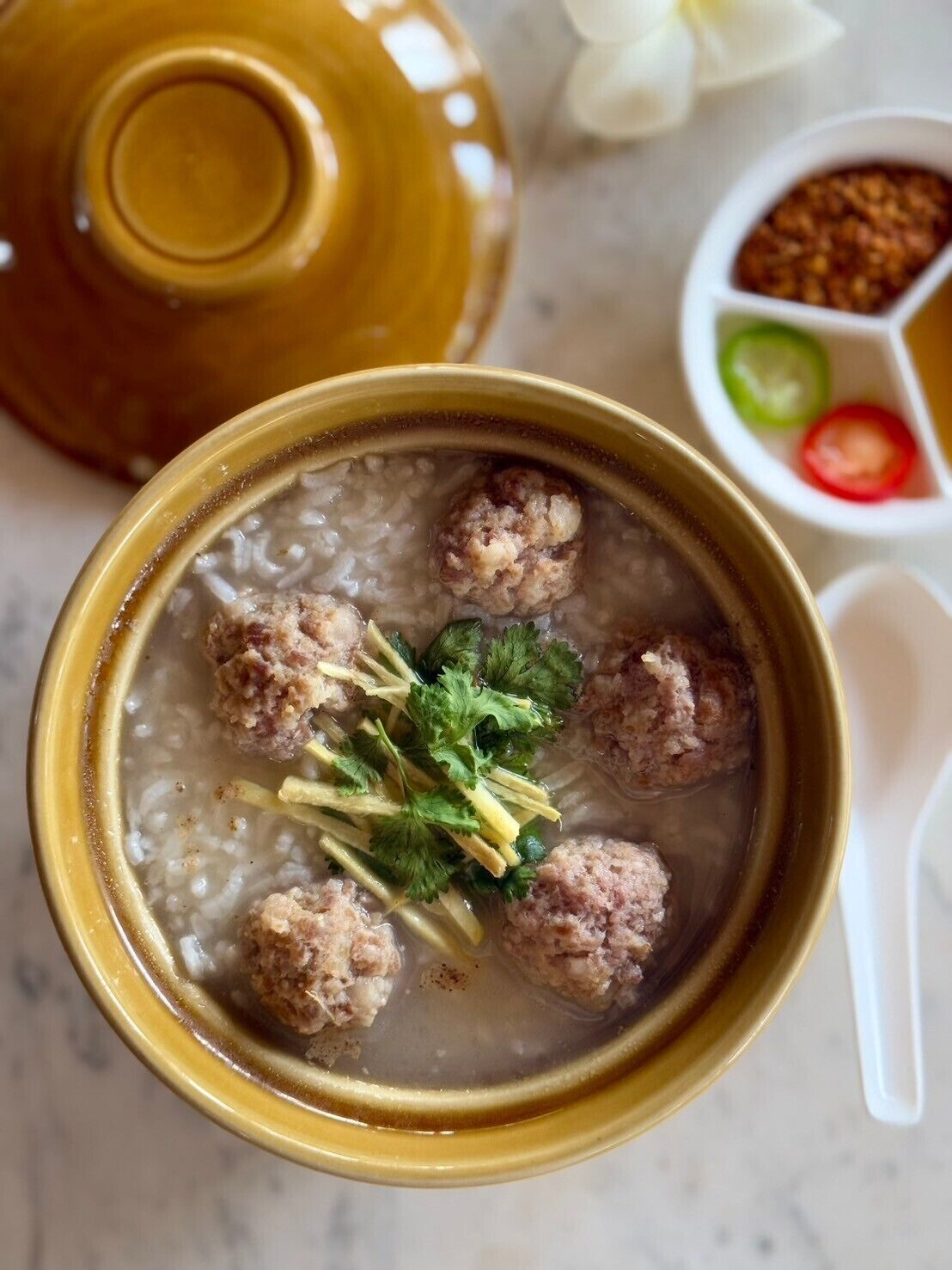 Un tazón de sopa con albóndigas y hierbas.