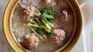 A bowl of soup with meatballs and herbs. - Suan Sang Chan Riverside Resort (Chumphon)