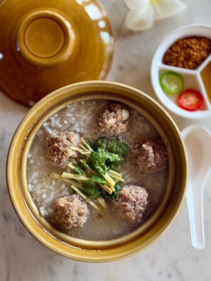 A bowl of soup with meatballs and herbs. - Suan Sang Chan Riverside Resort (Chumphon)