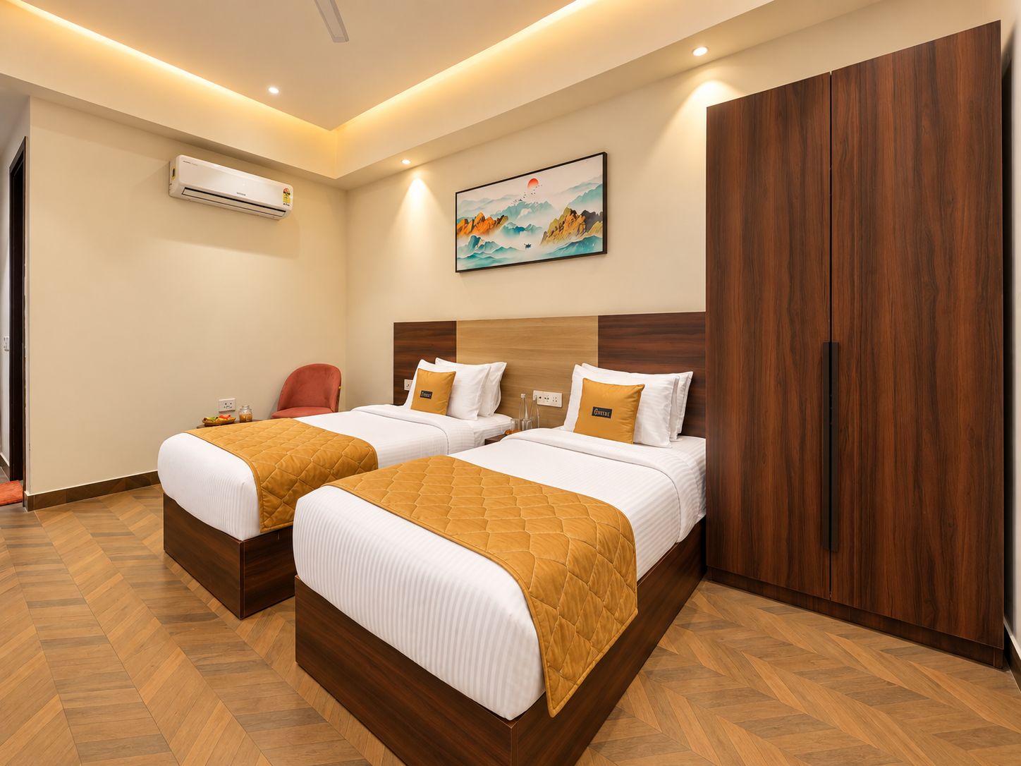 Una habitación de hotel con dos camas, un armario de madera, un equipo de aire acondicionado y un cuadro en la pared.