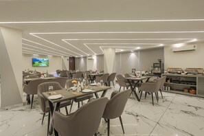 A modern dining area with tables, chairs, and a buffet. - The Altruist Gurugram Hotel (Gurugram)